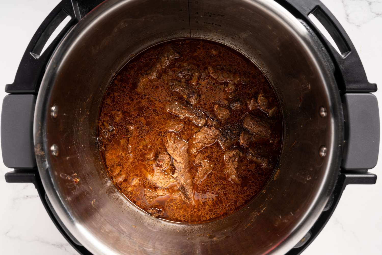 Browned carne asada with cooking liquid in the Instant Pot