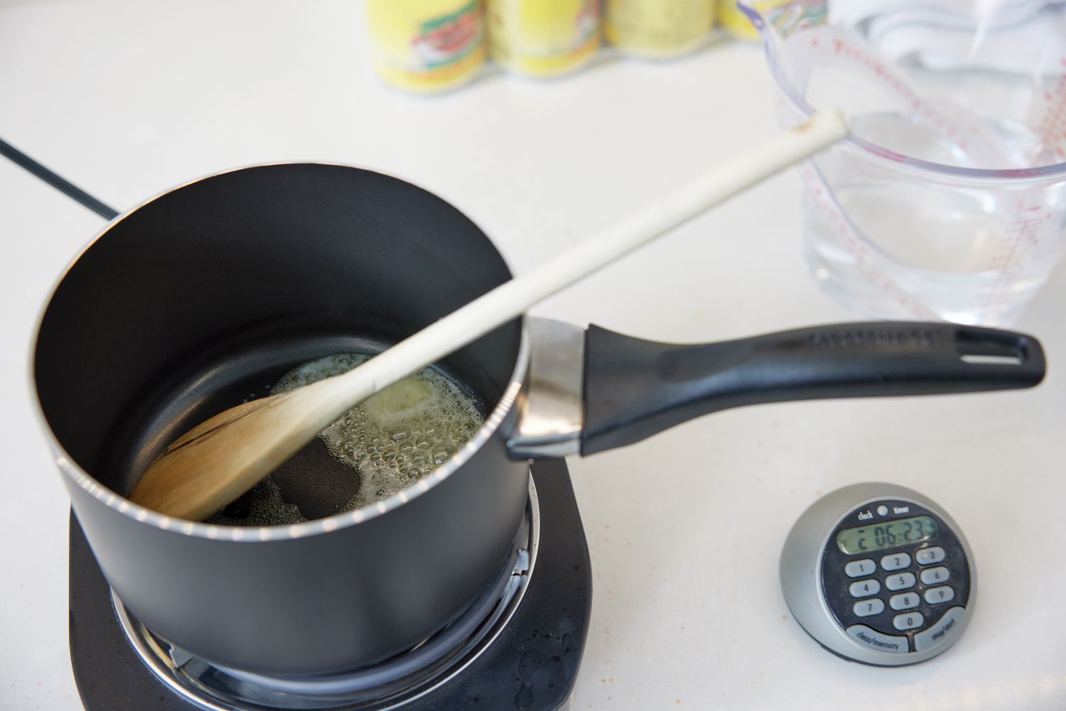 Wooden spoon and butter simmering in Farberware 15-Piece Aluminum Nonstick Cookware Set