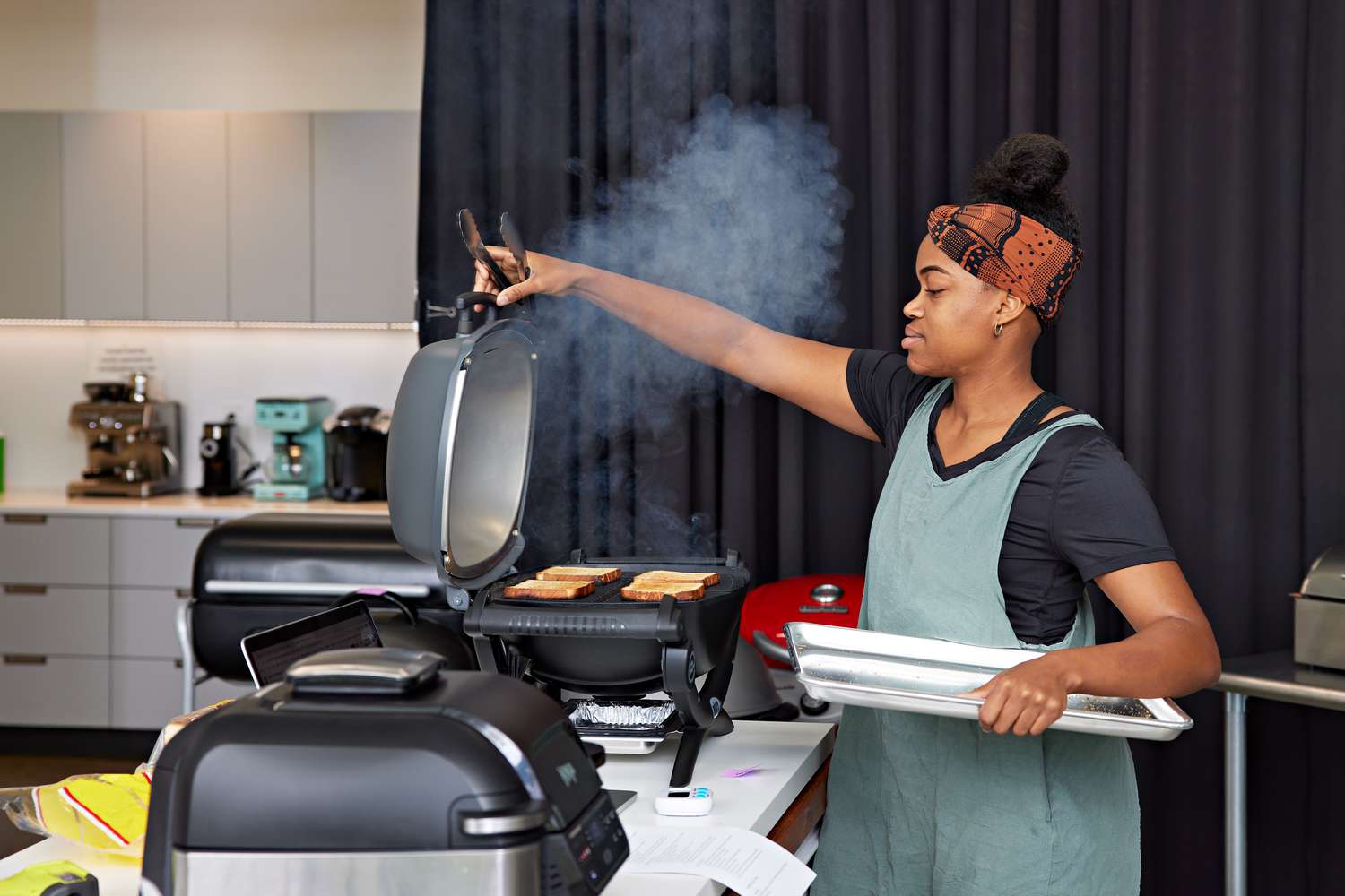 Woman opening the lid of the Weber Q 1400 Electric Grill