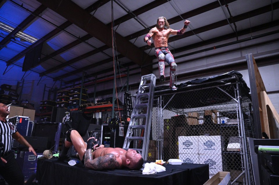  Edge sent Orton crashing through a table with a flying elbow drop