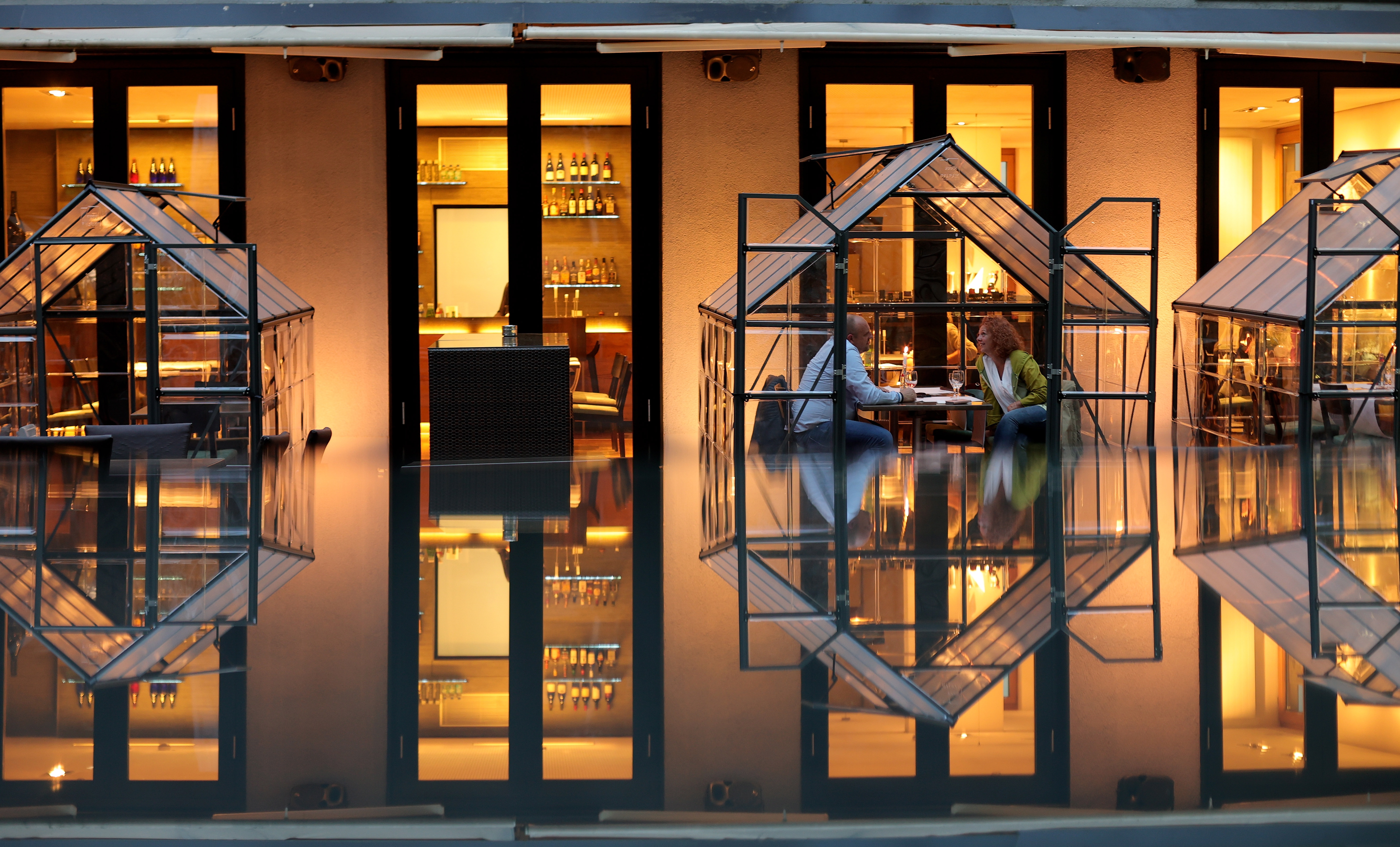  Guests sit at a table in a small greenhouse at the Novy's Brasserie Restaurant in Hagen, Germany