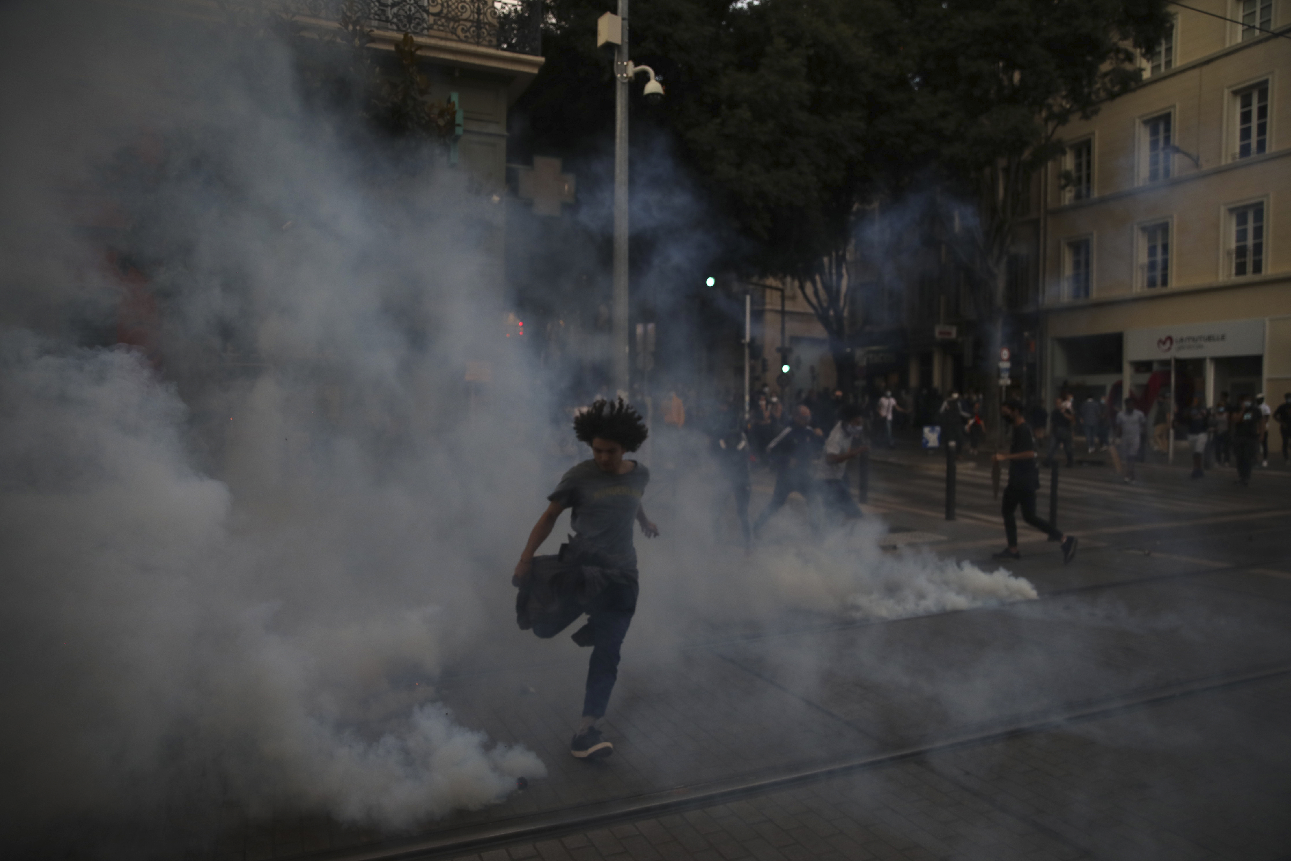  A woman runs through the smoke of teargas as police attempt to control the crowds