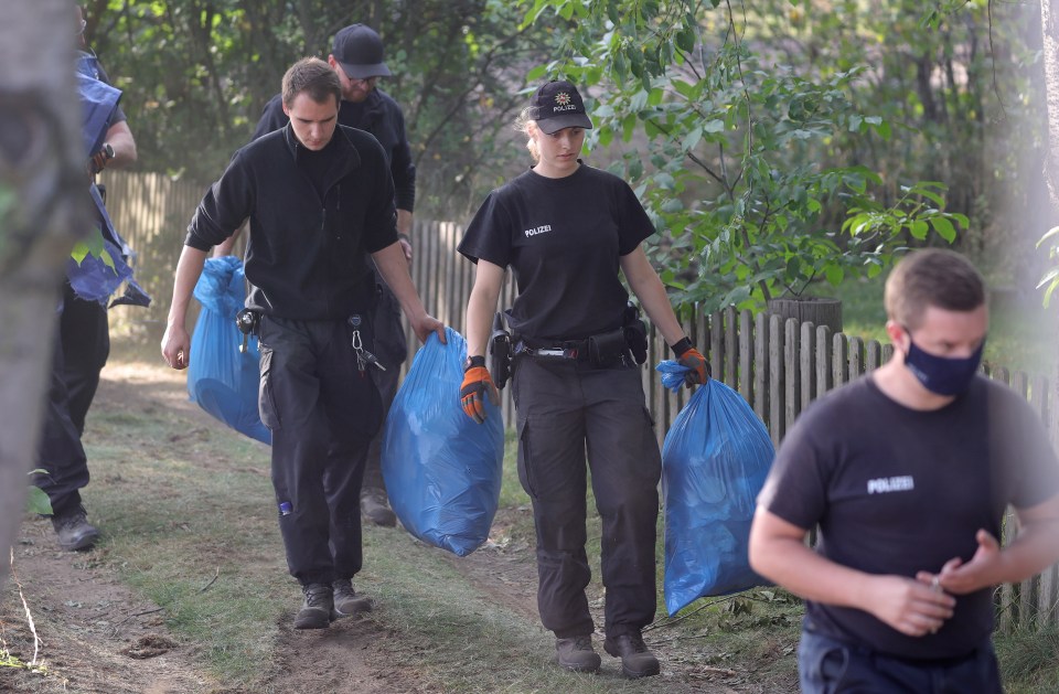 Police leave the site in Hanover holding plastic bags of items