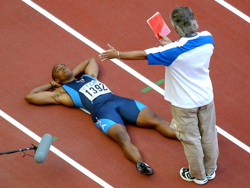 A race official shows Jon Drummond the red card after his false start at the 2003 World Athletics Championships in Paris