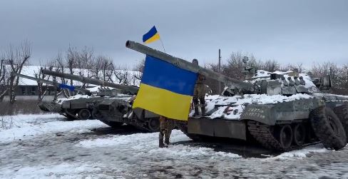 An abandoned Russian tank with the Ukrainian flag