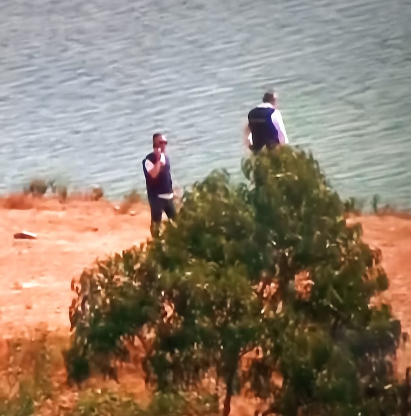 Police officers scour the shoreline as they prepare for the search