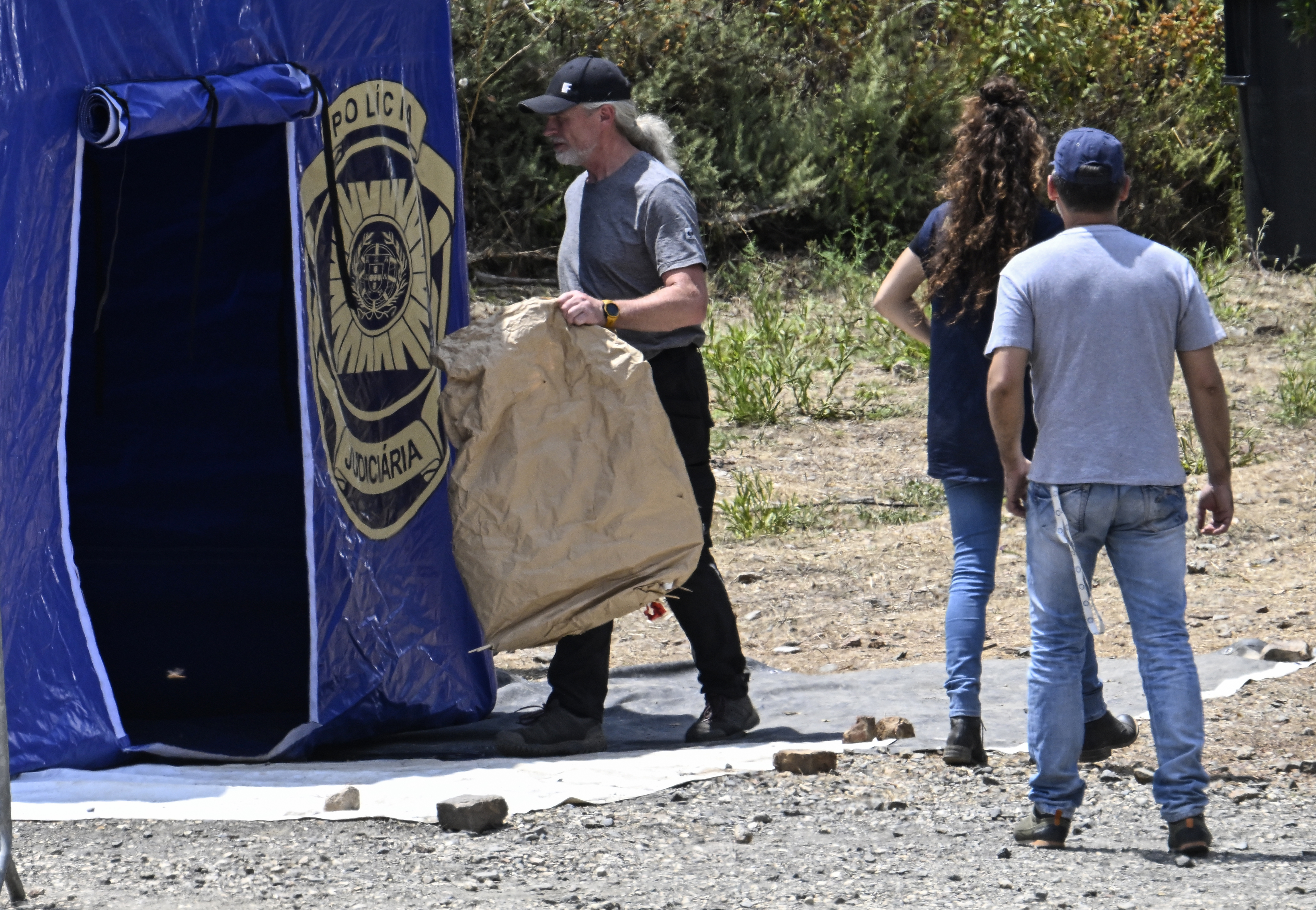 Cops were seen carrying large brown evidence bags from the search site