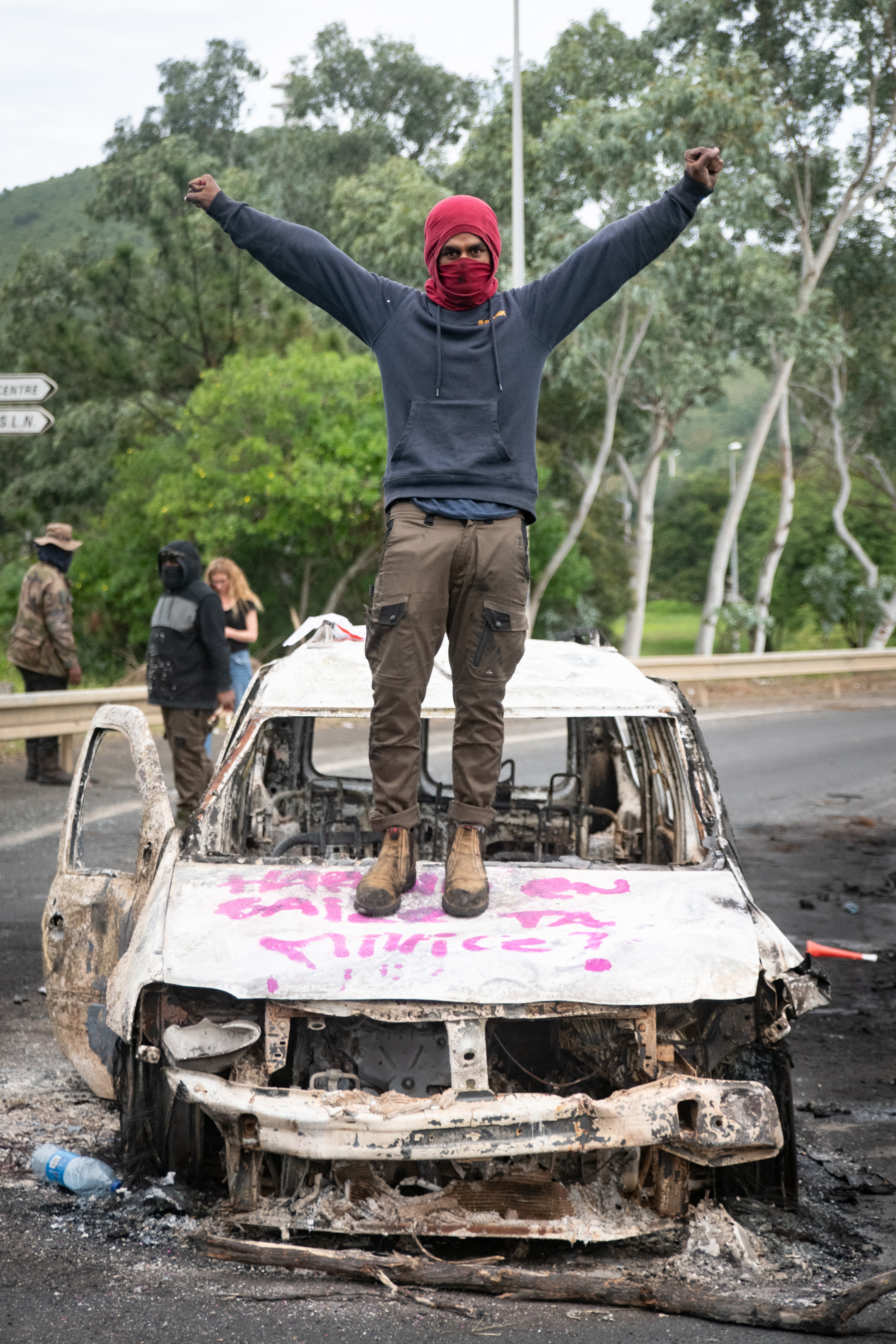 Burnt vehicles are stacked on top of each other to form roadblocks across the territory