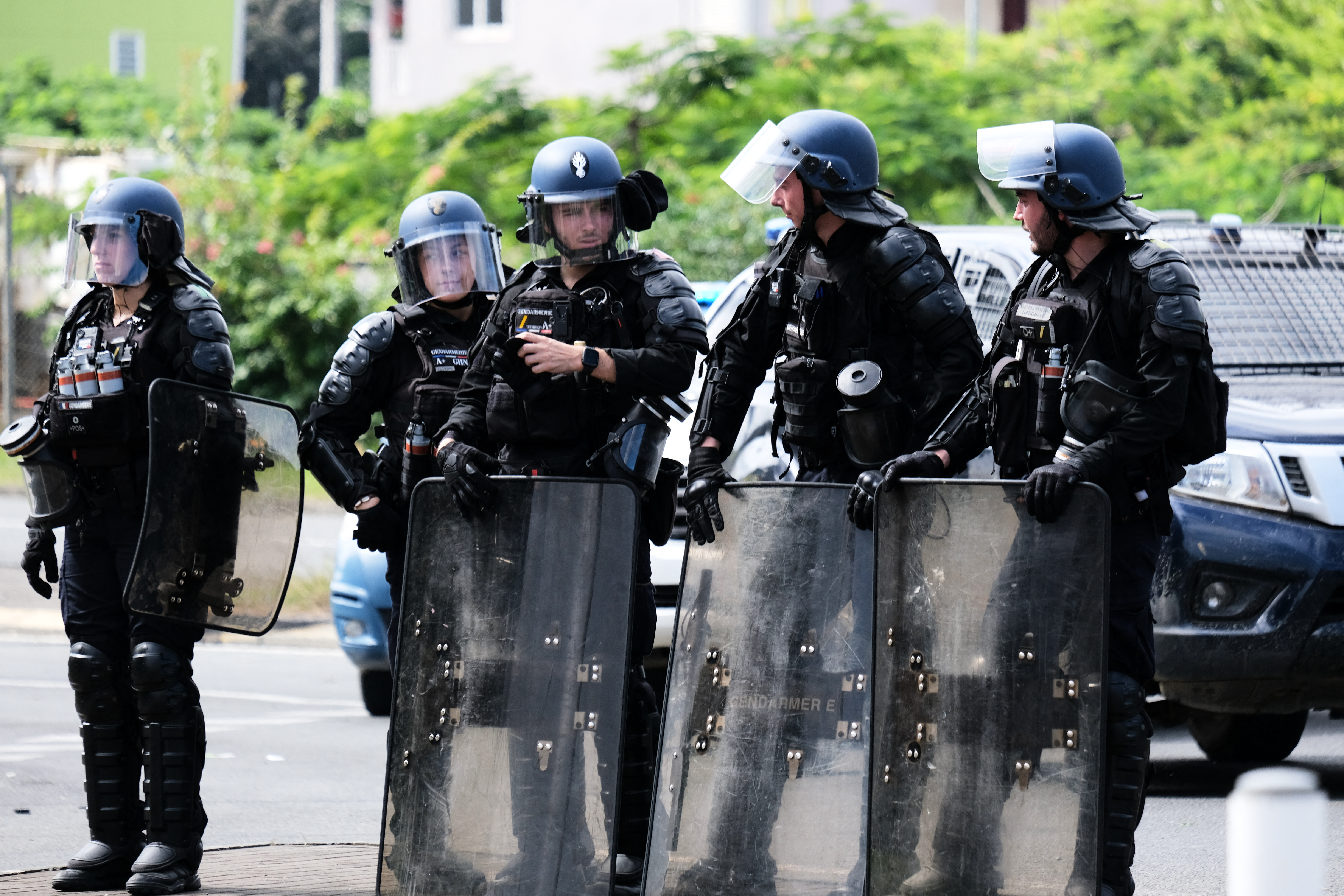 French Gendarmerie stand with their shields at the entrance of the Vallee-du-Tir district in Noumea