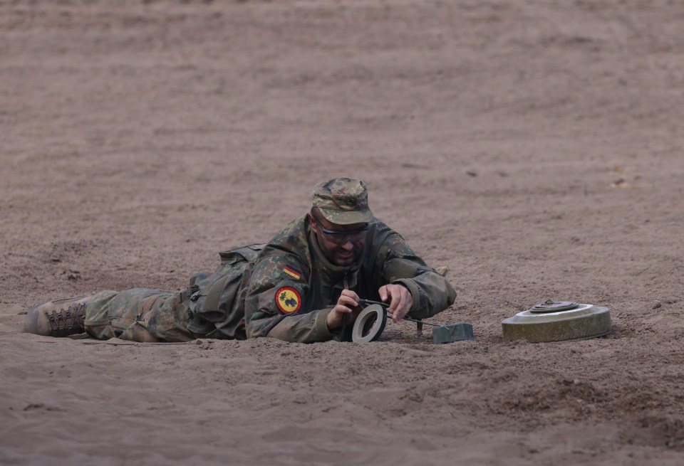 A soldier of the Bundeswehr demonstrates landmine removal