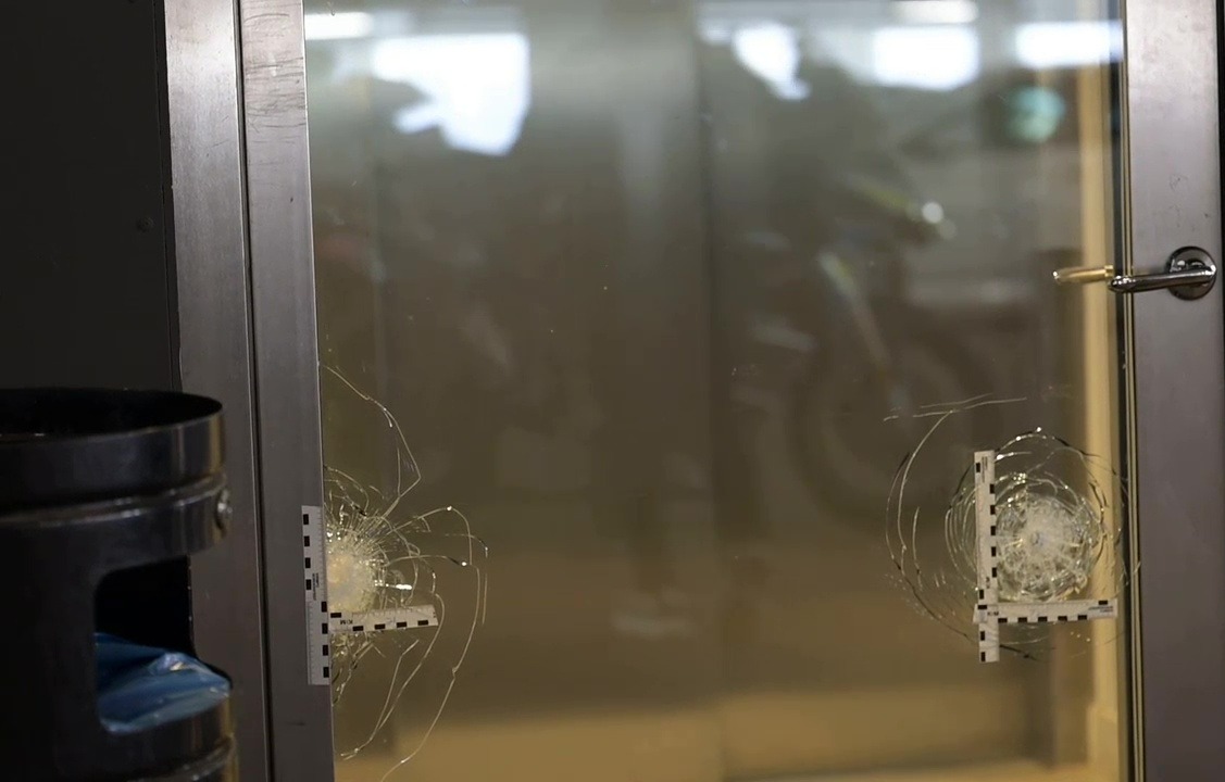 Authorities reportedly found seven bullet marks (pictured) on a glass door of the parking garage