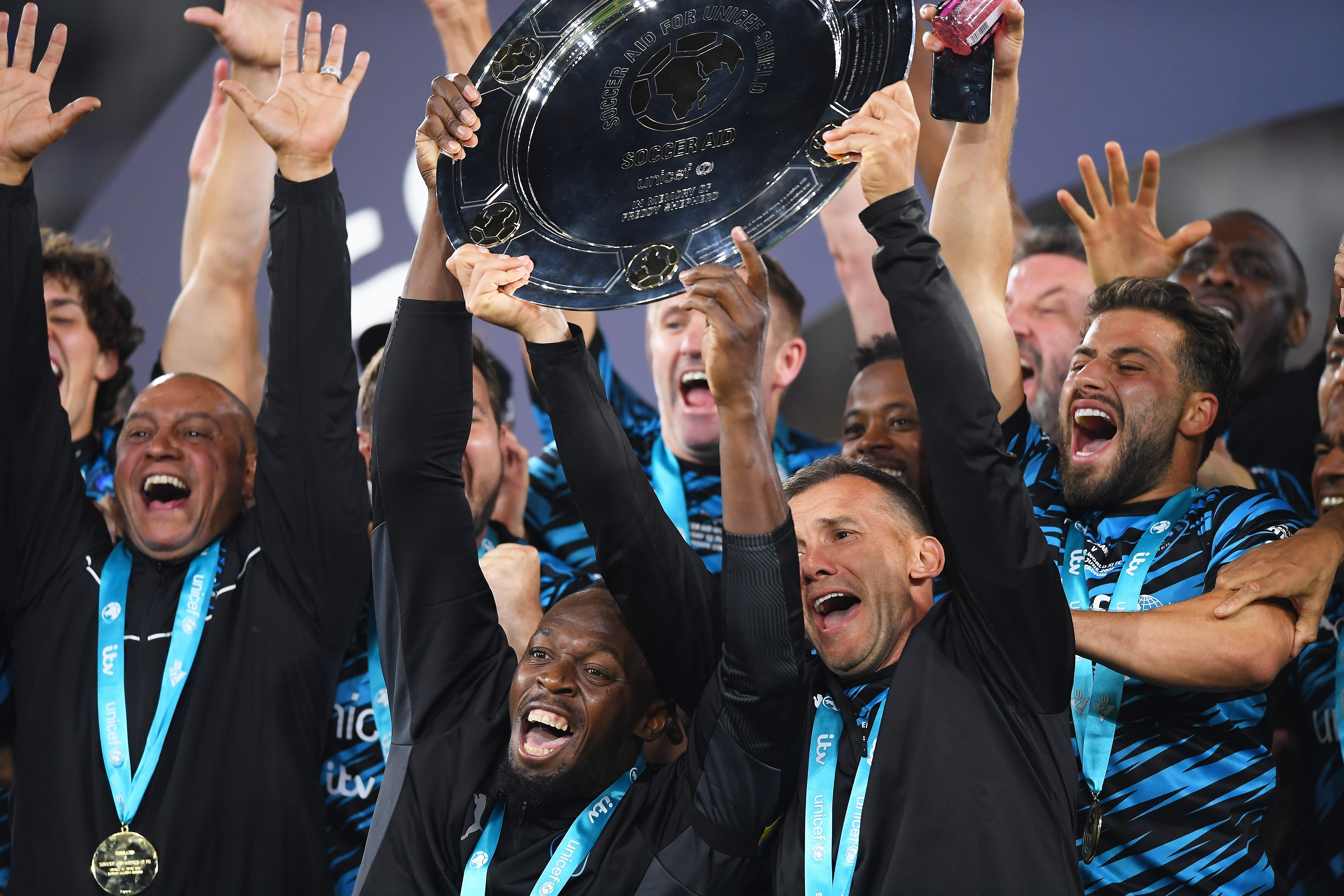  Usain Bolt, Andriy Shevchenko and members of Team World XI lifting the Soccer Aid 2022 trophy