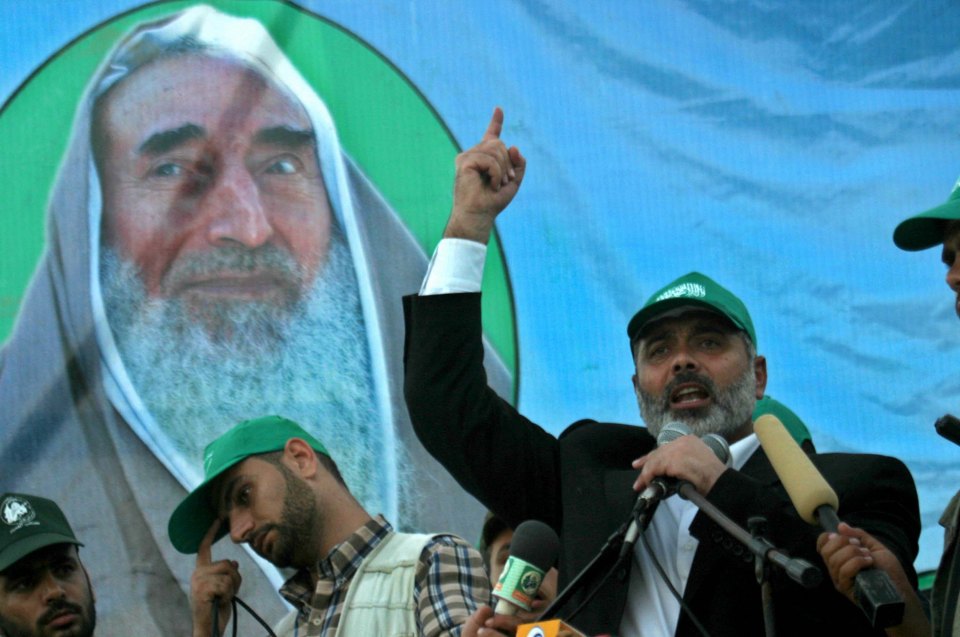 Ismail Haniyah standing in front of a portrait of mentor and Hamas founder Sheikh Ahmed Yassin