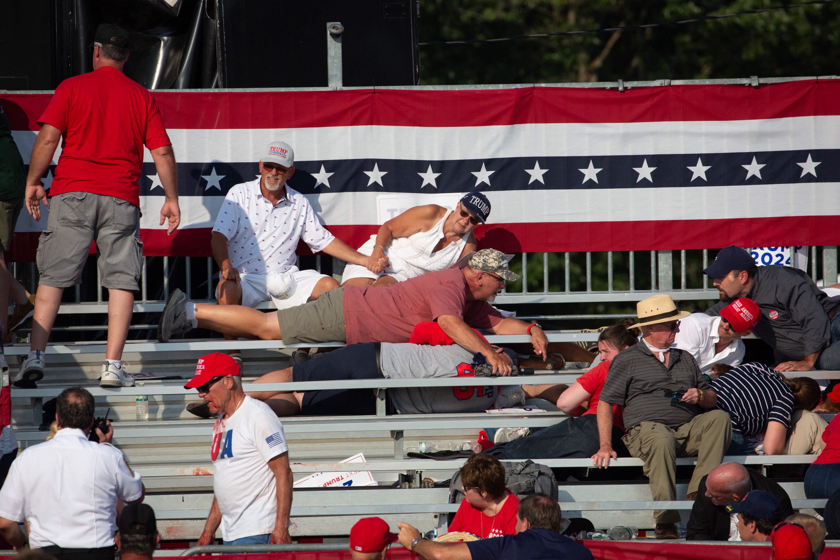 Trump supporters were seen running for safety and finding cover after shots rang out