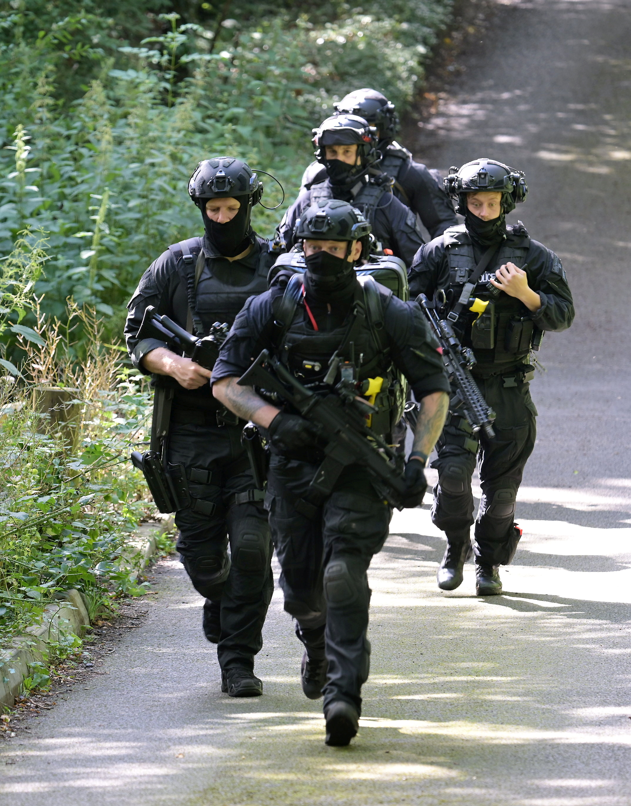 Armed police stormed the cemetery in the manhunt today