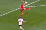 a soccer player with the number 12 on his jersey is kicking the ball .