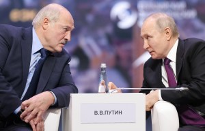 two men sit at a table with a sign that says v.b.putin