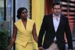 a woman in a yellow dress holds hands with a man in a suit