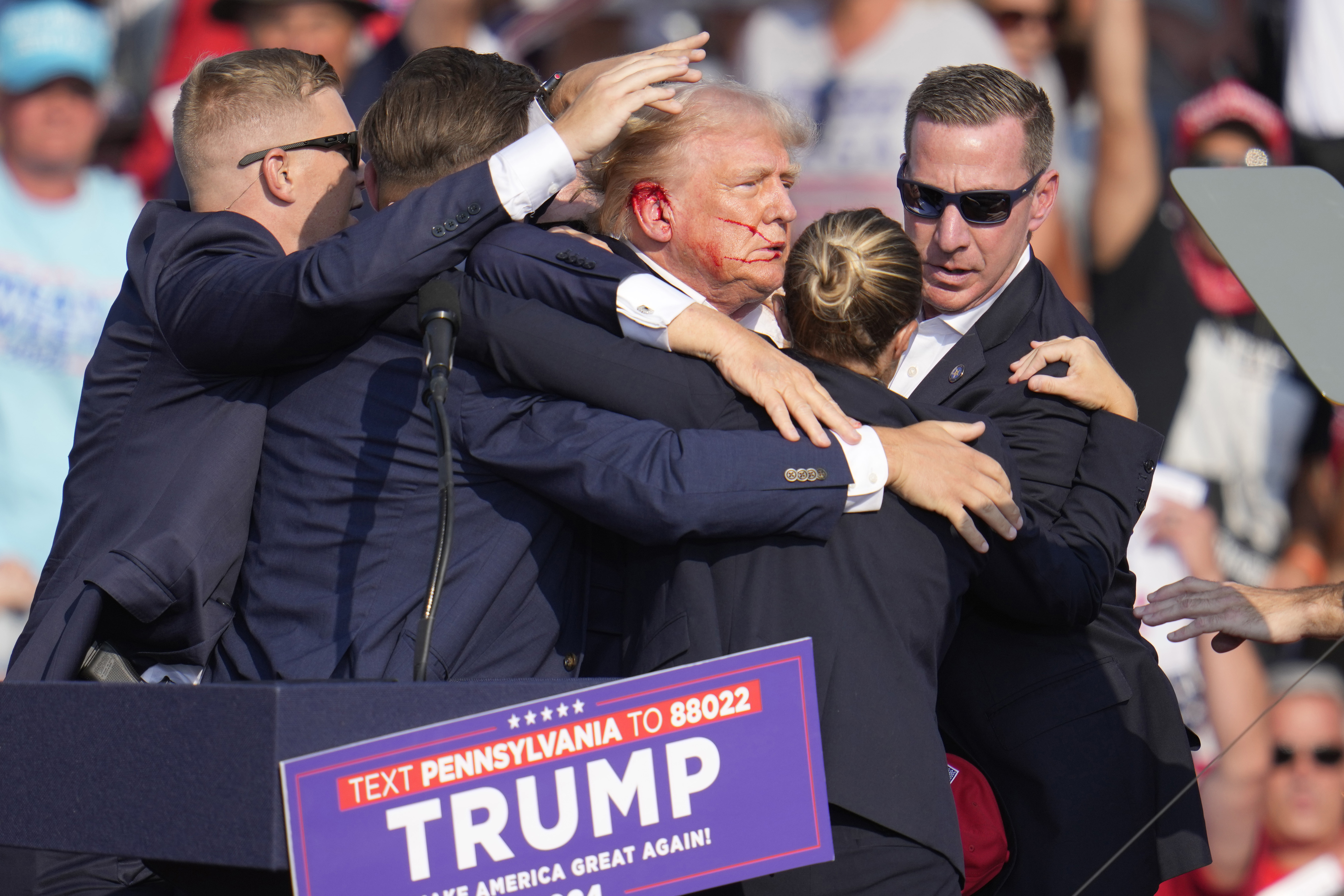 Former president Donald Trump is dragged away with a bloody ear by Secret Service agents