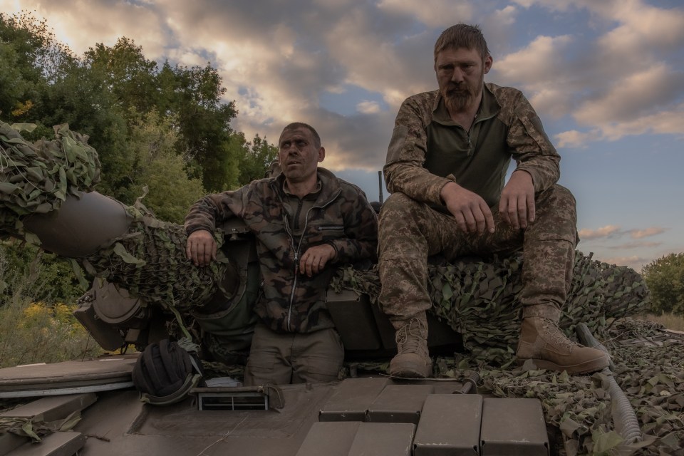 Ukrainian tank crew take a break while operating a Soviet-made T-72 tank in the Sumy region, near the border with Russia