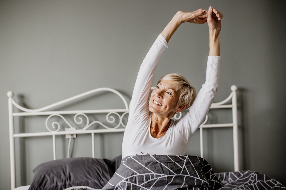 Senior woman wake up and she is stretching in bed