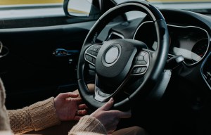a person is holding the steering wheel of a car