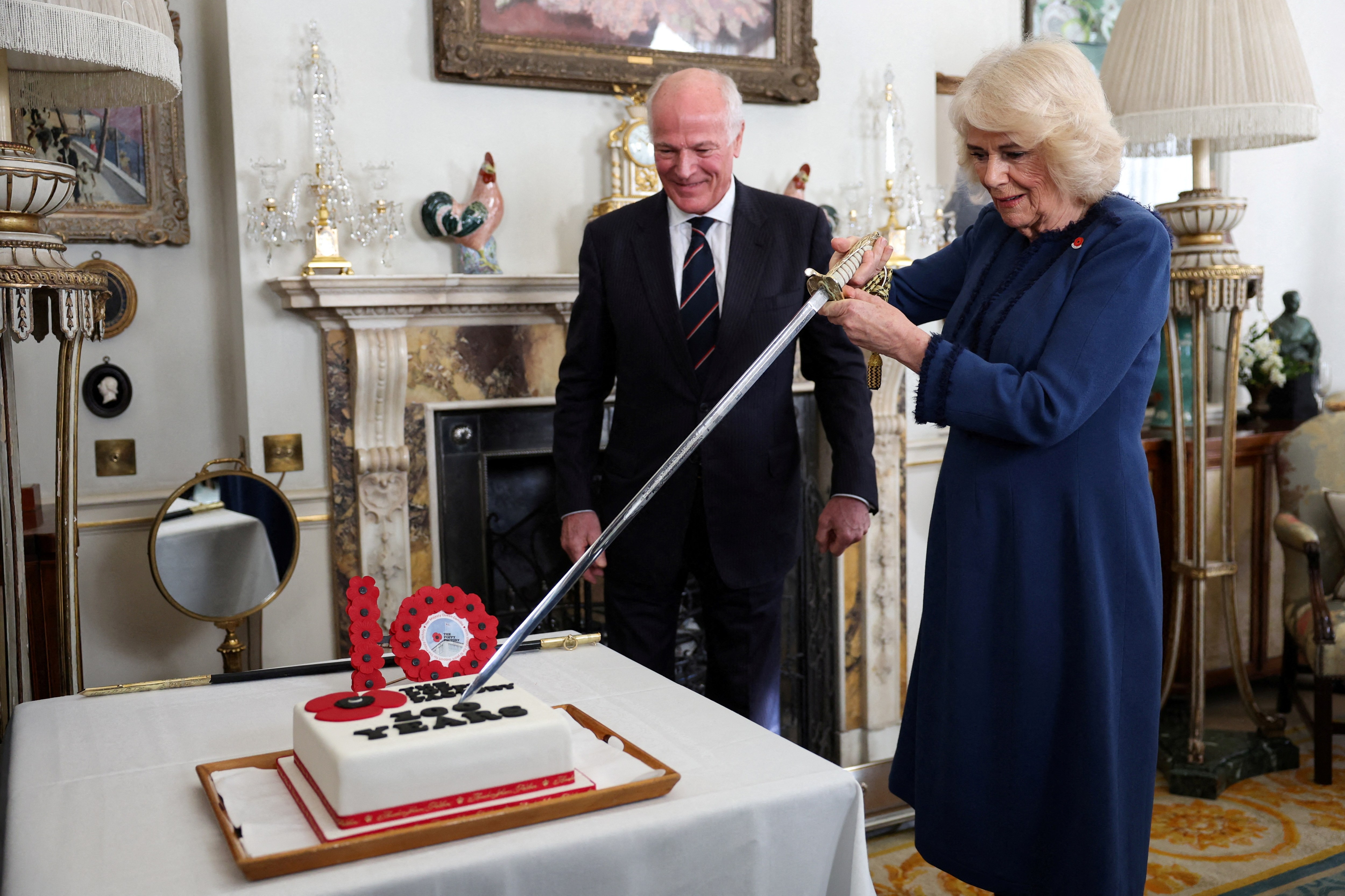 Cutting a cake at Clarence House to celebrate 100 years since the Poppy Factory moved to Richmond upon Thames