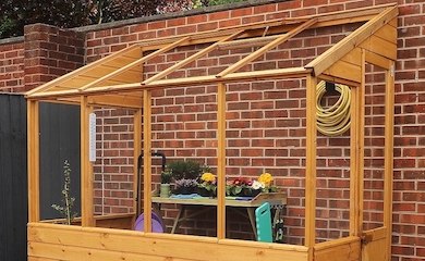 Wooden greenhouse against wall