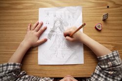 Girl drawing a person on paper