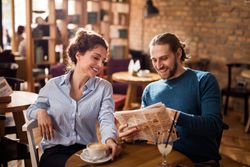 couple reading newspaper in coffee shop