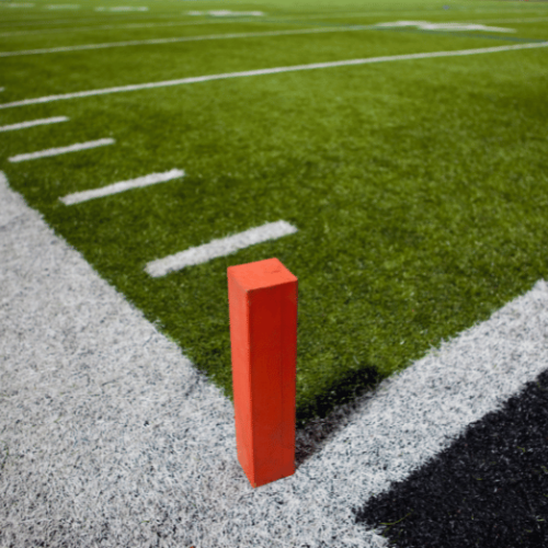 Photo of an endzone pylon on green football field.