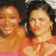 [Three models standing on the beach wearing Tower 28 Beauty products on their faces.]