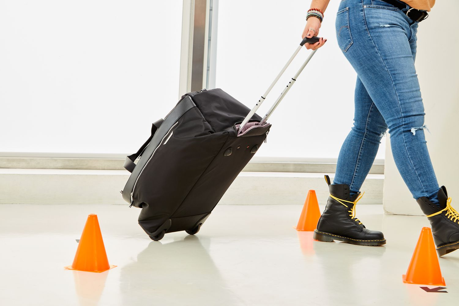 Person rolling Samsonite Just Right Weekend Wheeled Duffel around cones during testing