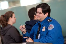 A Transportation Security Administration officer checks a passenger's identification