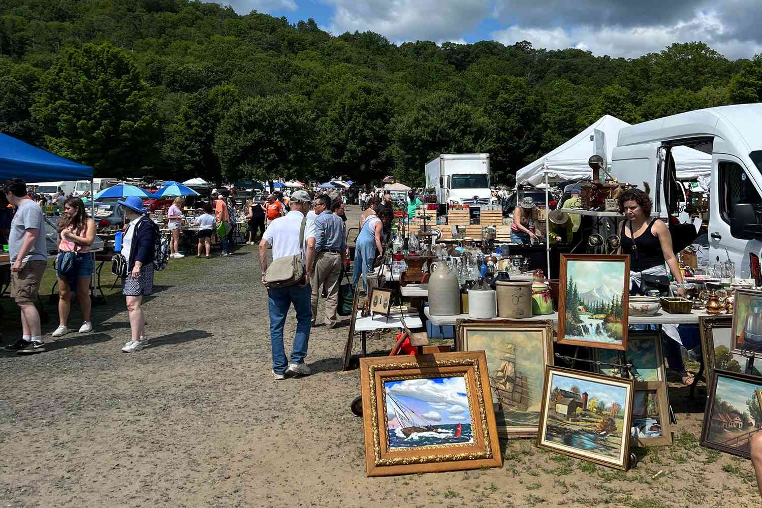 People walking around the Elephant Trunk Flea Market grounds in New Milford, CT