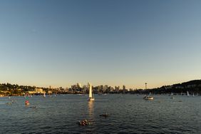 Kayaks and sailboats in the water at sunset in Seattle