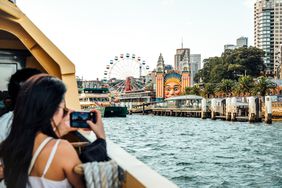 A person taking a picture of the Syndey skyline from a ferry