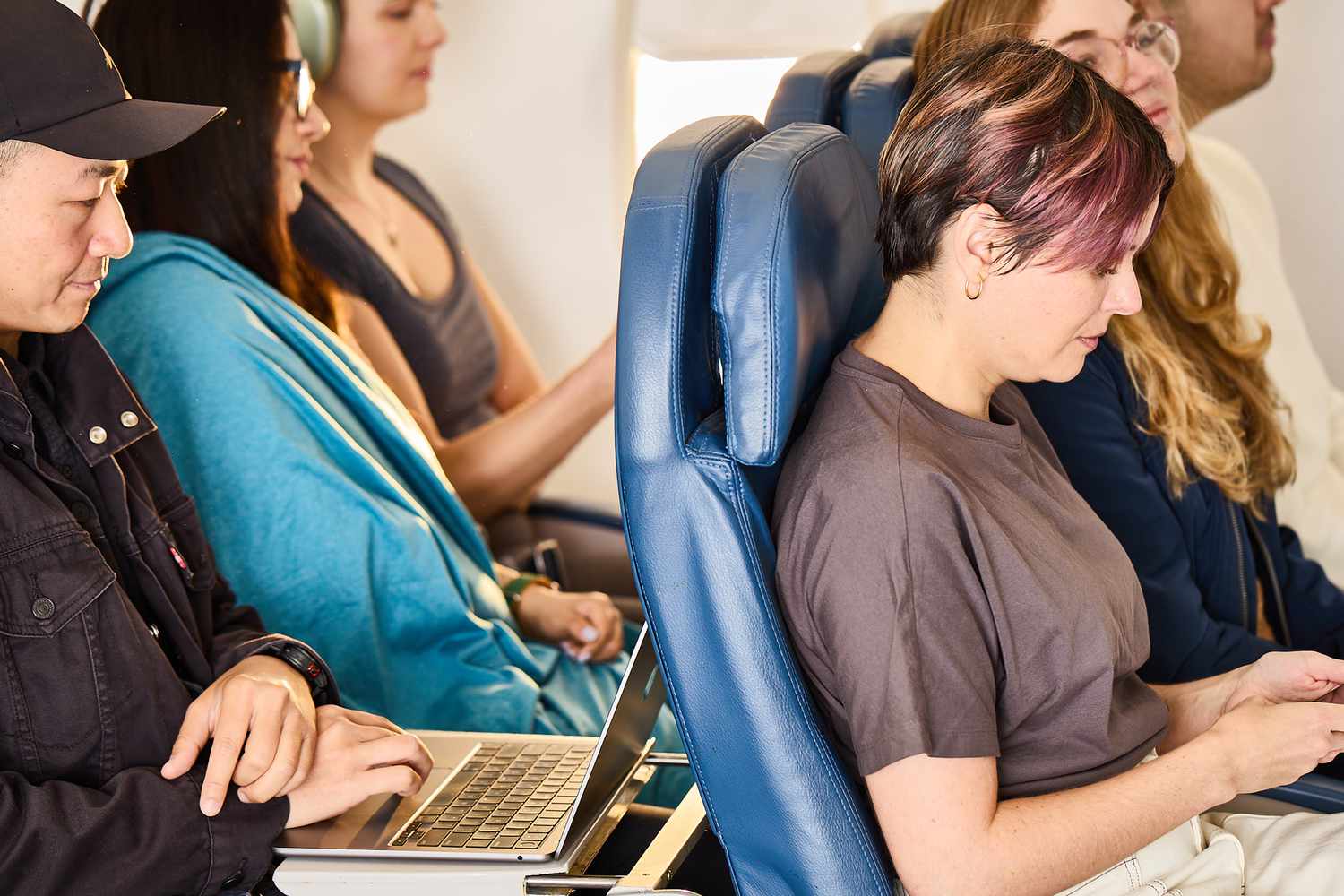 A person working on their laptop on a plane