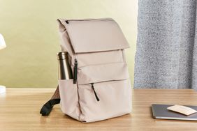 Everlane The ReNew Transit Backpack with stainless steel bottle displayed on wood table