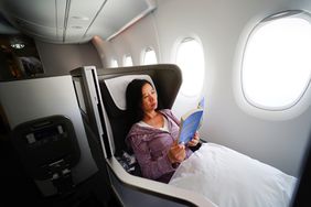 A woman relaxing on a first class flight with a book