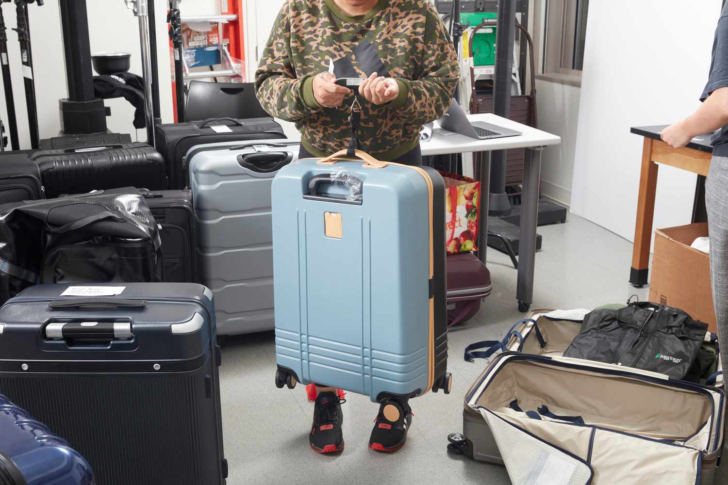 A person weighing the Roam The Check-In Luggage