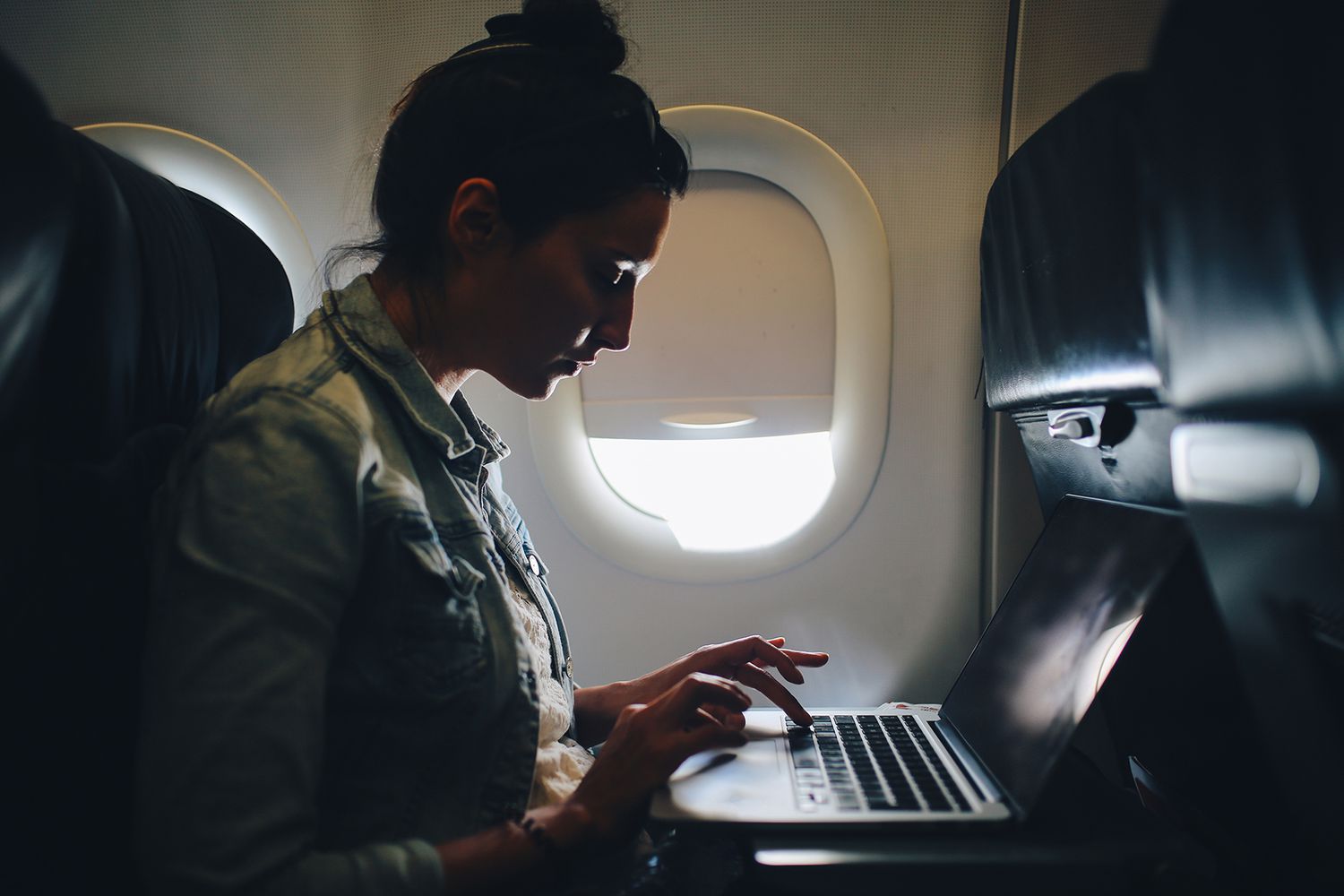 Young woman finishing her work in airplane