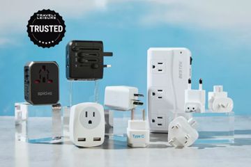 Group of several travel adapters displayed on a gray table and acrylic pedestals