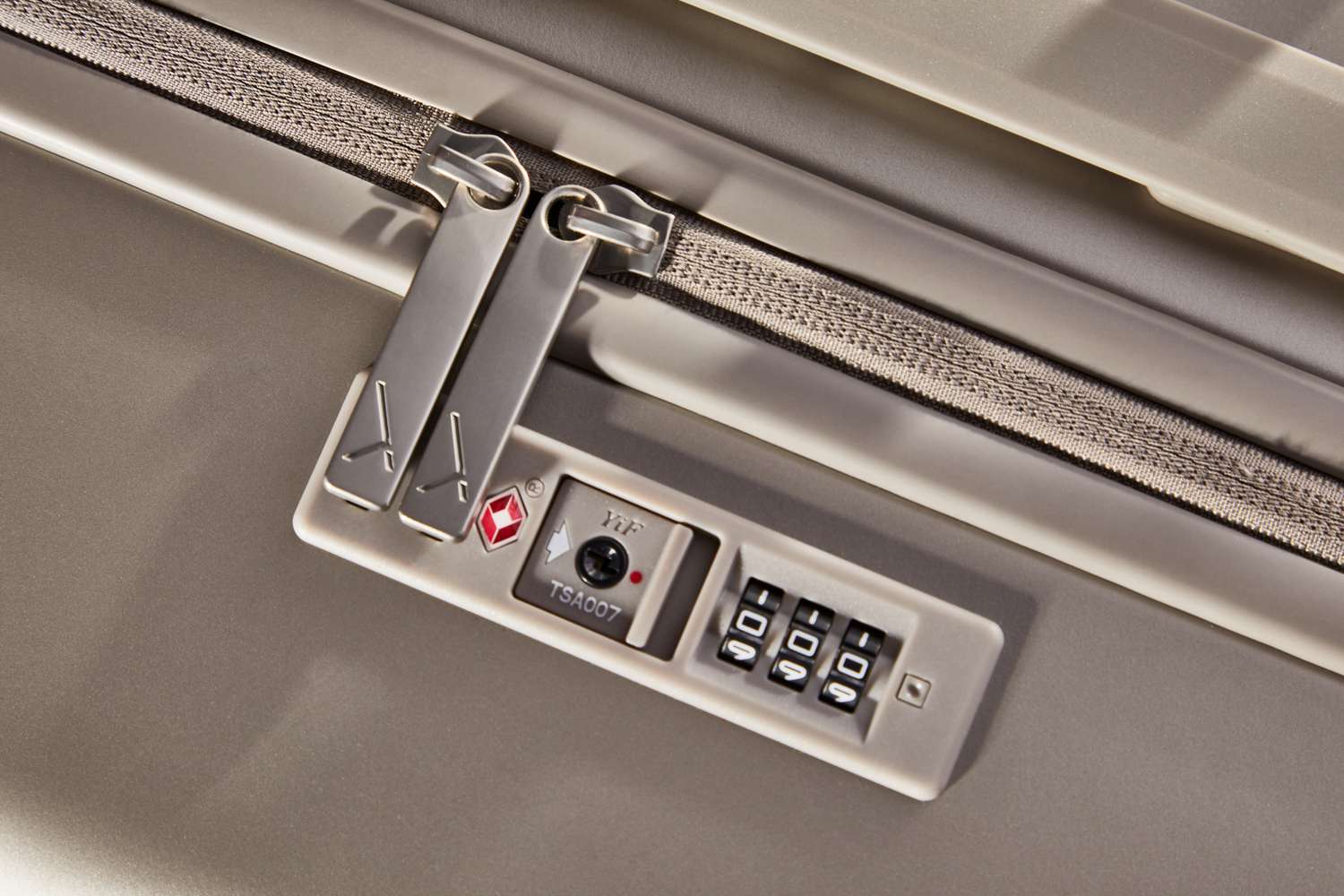 Close-up of the zipper and combination lock on the Arlo Skye The Zipper Check-In Medium