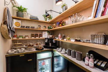 A hotel kitchen pantry with drinks, snacks, and baked goods