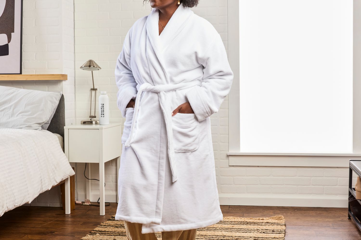 A person wears a Cariloha Bamboo Bath Robe in a bedroom setting