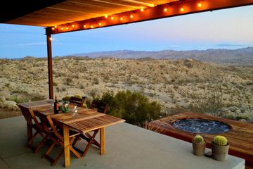 An outdoor dining table and hot tub at the Joshua Tree Green Haus /w Hot Tub in Yucca Valley, California