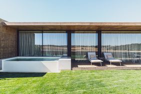 A windowed hotel guest room with the Portugal countryside reflected in the window