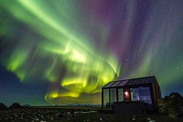 Glass house in Hella, Iceland, vast landscape views and nighttime view of Northern Lights