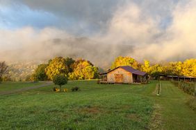 Steam from hot springs rising over large yard with event barn at Broadwing barn